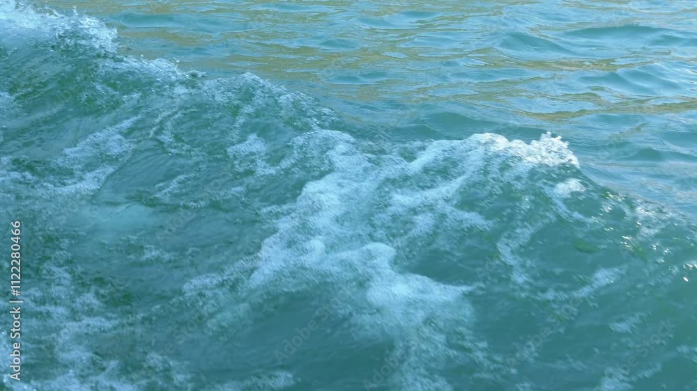 Poster close-up of foamy water trailing a boat, creating dynamic patterns and textures against a serene tur