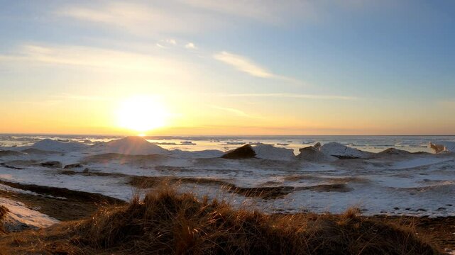 Lake Huron sunset over snow-covered sand dune beach near Goderich, Ontario, Canada 