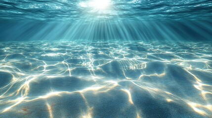 Underwater sunbeams illuminating sandy ocean floor.