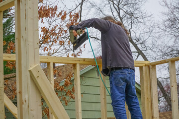 handyman working on building shed with nail gun