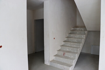 Fototapeta premium monolithic staircase, house before renovation, empty walls, construction 