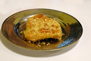 Close-up view of traditional Turkish cuisine's sherbet-filled dessert. Dessert served in a copper bowl. Turkish dessert art. Delicious desserts.
