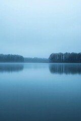 A serene lake scene under a soft blue sky, evoking tranquility.