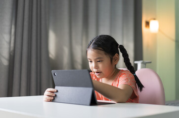 asian child learning drawing or writing on computer tablet screen by touch pen and study online class or kid girl student enjoy fun to video call studying or person happy learn from home school on pad