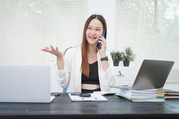 A young, professional businesswoman working at her desk in an office, providing online legal...