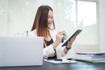 A young, professional businesswoman working at her desk in an office, providing online legal...
