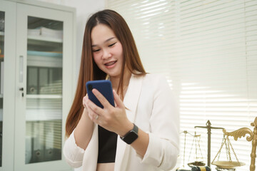 A cheerful businesswoman works at her office desk as a legal consultant, handling online civil...