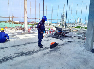 Worker sweeping debris at a construction site. Construction Site Sweeping