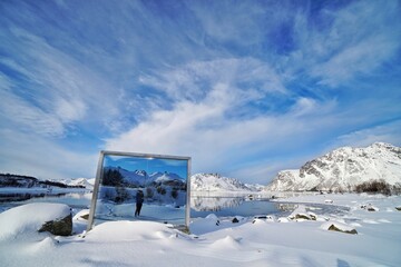 A mirror reflect the lake and snow mountain at Norway.