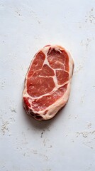 Fototapeta premium A raw cut of meat, showcasing marbling and texture, ready for cooking or preparation.