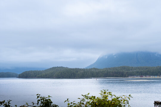 A foggy morning in a Pacific Ocean bay with mountains in the background and the ocean