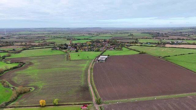 UAV Drone of Hardwick village in Buckinghamshire surrounded by farm fields and a cattle shed