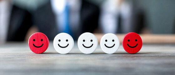 A series of smiley face tokens, showcasing varying expressions, set against a blurred professional background, symbolizing feedback and emotions.