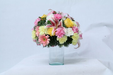 Many kinds of flowers placed in a brightly colored vase