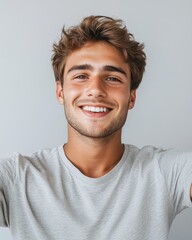 Fototapeta premium Happy Young Man Smiling, Close-Up Portrait of Attractive Caucasian Male with Brown Hair and White Teeth, Wearing Gray T-Shirt