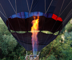 Obraz premium A hot air balloon with a red and orange striped body is floating in the sky