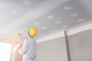 Craftsman working with plaster gypsum ceiling for interior build gypsum board ceiling in construction site before decorating. © noppadon