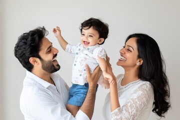 A happy south asian family of three: a father carrying his one-year-old son on his shoulders, while a smiling mother sits in beside them