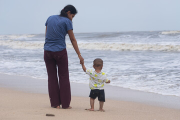 Single mother with baby at beach. Sea trip picnic insurance future NPS Vatsalya life education...