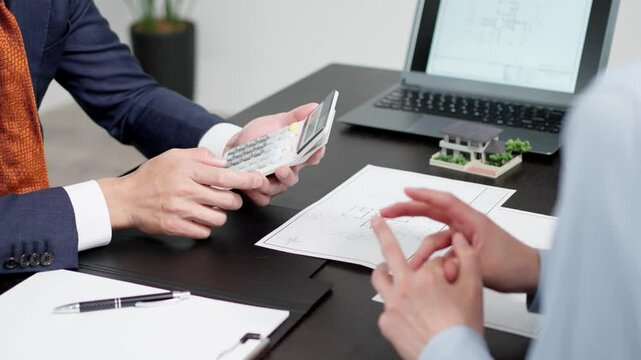 不動産の見積もりを計算するビジネスマン