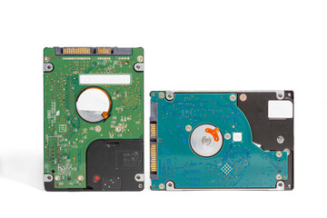 A pair of internal notebook 2.5 inch SATA hard disk drives. The drives are positioned against on white background. One drive reveals its internal components, showcasing the circuit board and plat
