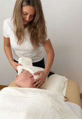 Beautiful woman in spa salon receiving head massage