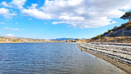 Fototapeta premium In autumn, a view of the Lake Emre which is a serene natural oasis, surrounded by lush greenery and ancient rock formations in the heart of Phrygian Valley in Afyonkarahisar.