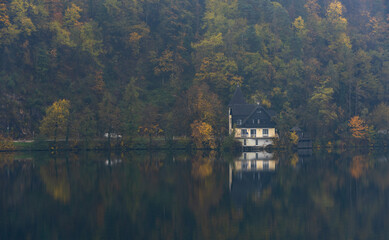 Fototapeta premium Fog rolling over the lake and forest in autumn. Lake Bled Slovenia