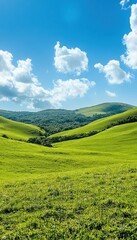 Fototapeta premium Lush green hills under a bright blue sky with fluffy clouds.