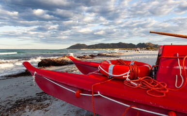 Rescue boat at the beach in Sardinia, Italy. Mediterranean coast in Sardinia on a cloudy day with a...