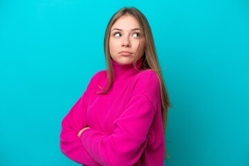 Young Lithuanian woman isolated on blue background making doubts gesture while lifting the shoulders