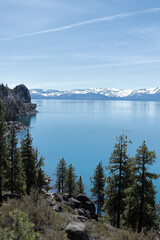View of the blue lagoon of Lake Tahoe. Coniferous forest and trees growing on the shore.