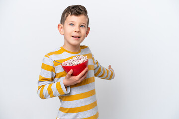 Naklejka premium Little caucasian boy holding a cereal bowl isolated on white background extending hands to the side for inviting to come