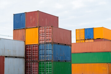 Fototapeta premium A stack of containers with different colors and sizes. Concept of organization and structure, as the containers are neatly stacked on top of each other. The variety of colors adds visual interest