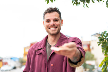 Young caucasian man at outdoors taking a lot of money