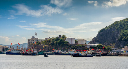 Fototapeta premium Vibrant Harbor Scene with Fishing Boats and Coastal Landscape