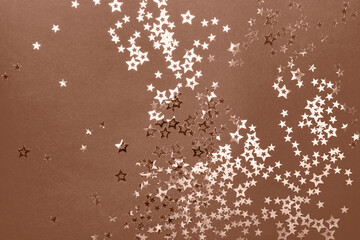 Christmas festive background in mocha mousse color with confetti stars