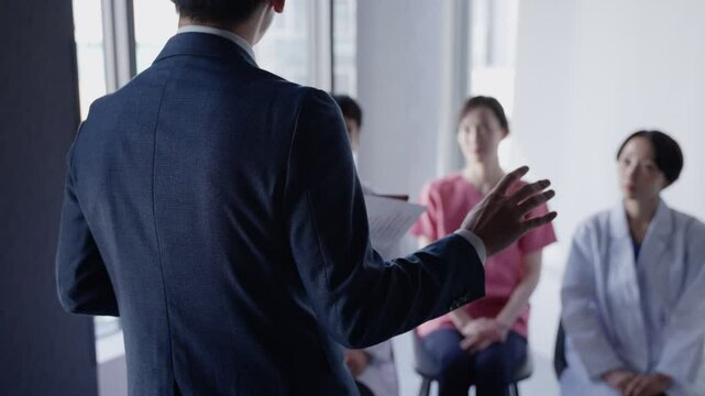 医者にプレゼンテーションするビジネスマン