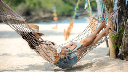 Lifestyle freelance women relax and sleeping on the hammock after using laptop working and relax on...