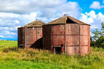 Two old red barns sit in a field