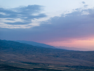 Fototapeta premium Mountain landscape in summer at sunset. Fields and lake near the mountains. Top view, drone photo.