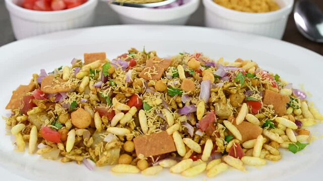 Serving bhel puri Indian chaat dish in a plate.
