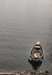 Obraz premium Traditional hand built small wooden rowboat slowly in warm evening light was resting along in the dam. use it as your Wallpaper, Poster and Space for text, Selective focus.