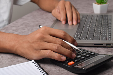 Businessman using calculator for payroll bookkeeping and tax budget. Financial business documents accounting investment