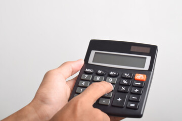 Hands holding and using a calculator isolated on a white background