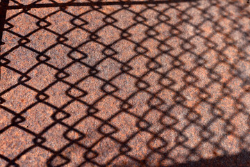 Naklejka premium old iron sheet. falling shadow. Old cracked, Rusty metal surface. Rusty steel. vintage style. rusty iron. for background and text. close-up. oxidation, destruction. mesh shadow on surface