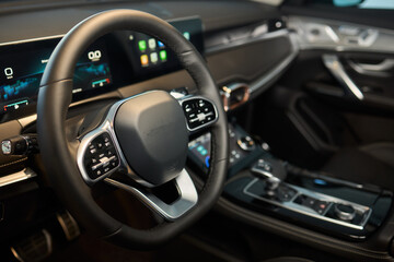 Obraz premium Closeup of a modern car steering wheel with control buttons for technology and convenience