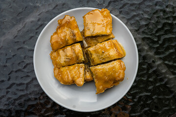 Top view of a signature dish of Pontianak, Indonesia called srikaya fried banana on a glass table