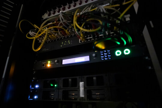 Dark server room with LED lights.  Central computer technology room of a small business.