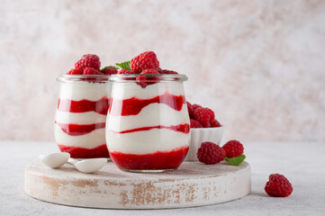 Vanilla white chocolate mousse, trifle, panna cotta or parfait with raspberry sauce in a glass jar....